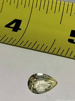 Gemstone beside tape measure showing length around 13 mm