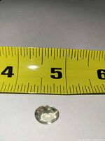 Gemstone beside tape measure showing size reference