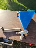 Sharpshooter I spray gun with blue hopper and OLT CB370 tool on table