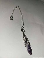 Full view of amethyst pendulum on chain