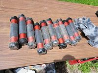 Ten red and black XCO shaker weights laid on table