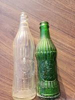 Front view of both clear and green Reinhart bottles