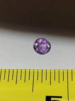 Top view showing round faceted amethyst next to ruler for scale