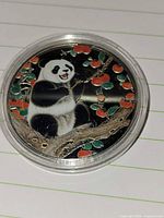 Obverse showing panda with enamel color details in capsule