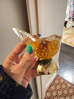 Amber glass bird-shaped bottle on gold-tone base