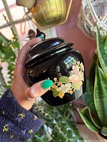 Ginger jar with lid held in hand showing overall form and glazing
