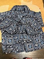 Full view of folded navy geometric floral fleece jacket