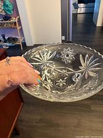 Top view of clear pressed glass bowl showing starburst pattern and scalloped rim