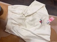 Full view of cream sweatshirt with heart embroidery and hang tag