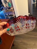 Side view showing clear cut glass body and ruby flashed scalloped rim