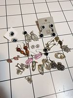 Overview of all twelve earring pairs on grid background