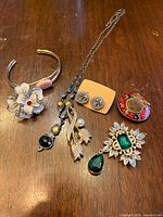 All five jewelry pieces on wood surface