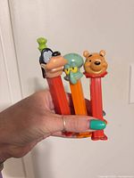 Front view of three PEZ dispensers held in hand