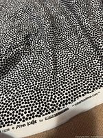 Full view of fabric showing polka dot pattern and selvage text "Ann Kelle for ROBERT KAUFMAN"