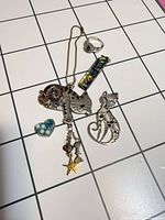 All seven jewellery pieces laid out on grid background