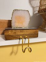 Front view of wood block with rose quartz slice and gold hook