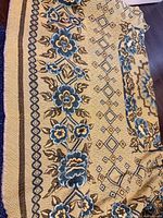 Full view of throw showing main floral border and geometric center pattern