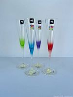 Front view of four coloured champagne flutes, labels visible