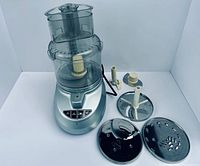 Overall view of food processor base, bowl, lid, three discs, and disc stem
