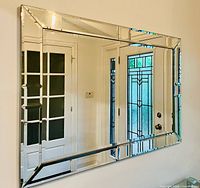 Front view showing rectangular mirror and beveled mirrored-glass frame