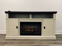Front view showing fireplace insert lit, cabinets and shelves