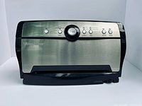 Front view of FoodSaver vacuum sealer showing buttons, dial, stainless panel, power cord