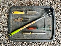 All five hand garden tools laid on black tray
