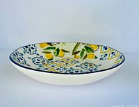 Side profile of ceramic serving bowl showing depth, white exterior, navy rim