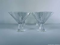 front view of four matching clear martini glasses