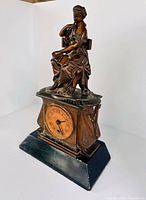 Front angled view showing statue, dial, and base
