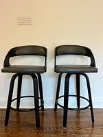Front view of two swivel bar stools showing seats, backs, legs
