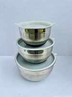Three stainless steel bowls stacked, lids visible