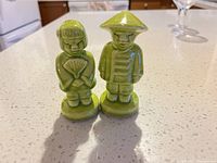 Front view of green ceramic figurine boy and girl shakers