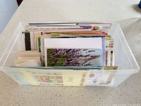 Clear plastic bin filled with assorted cards