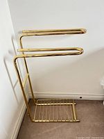 Full view of brass-plated metal towel rack showing overall design