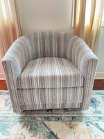 Front view of striped barrel accent chair showing upholstery and shape