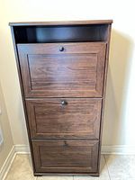Front view of closed walnut laminate shoe cabinet