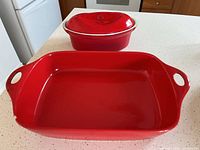 Both red baking dishes and lid on countertop