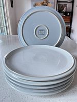 Stack of six Denby plates with one inverted showing back stamp