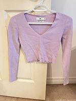 Front of lilac ribbed V-neck long-sleeve crop top on hanger
