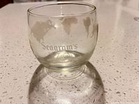 Close-up of single rocks glass showing etched world map and Seagram's VO logo