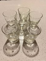 Six clear rocks glasses grouped on countertop