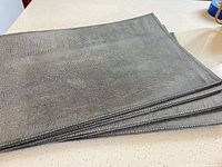 Stack of four silver-gray placemats
