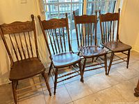 Four matching carved pressback chairs side by side