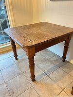 Full view of oak dining table showing rectangular top and turned legs