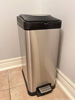 Front view of stainless steel trash can showing foot pedal and stainless body
