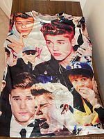 Front view of full T-shirt laid flat showing collage graphic