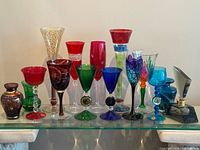 Full group shot of all coloured art glass pieces on glass shelf