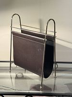 full view of chrome frame magazine rack with brown faux leather sling