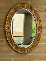 Full view of giltwood oval mirror on wall